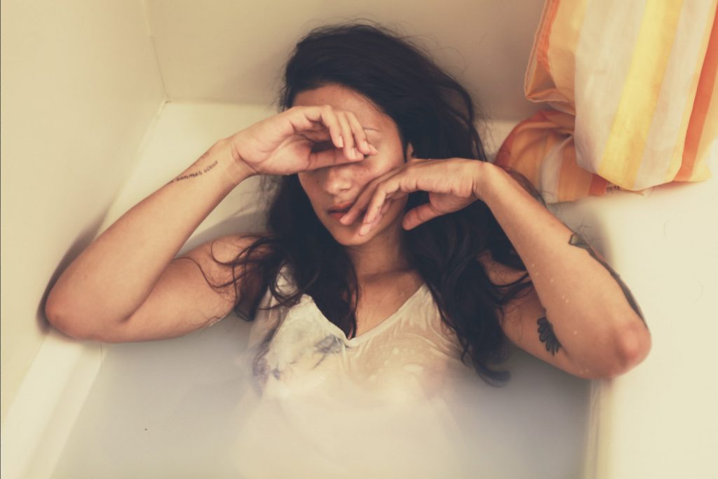 women depressed and crying in tub full of tears