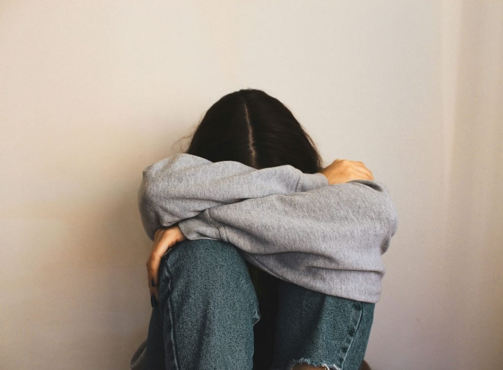 woman isolated on bedroom floor crying and depressed