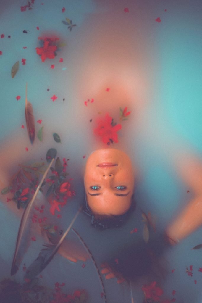 Woman soaking in a healing bath with milk and flowers